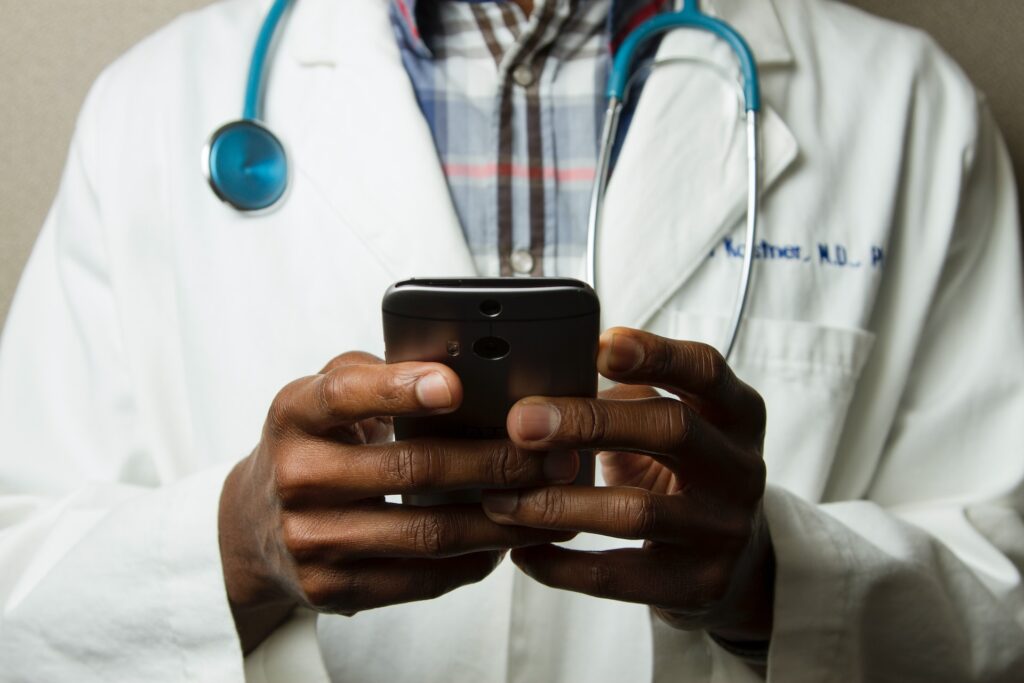 Un infirmier tenant un téléphone dans ses mains.